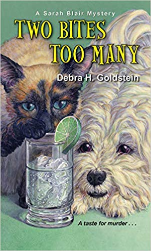 a cat and a dog looking at a glass of liquid