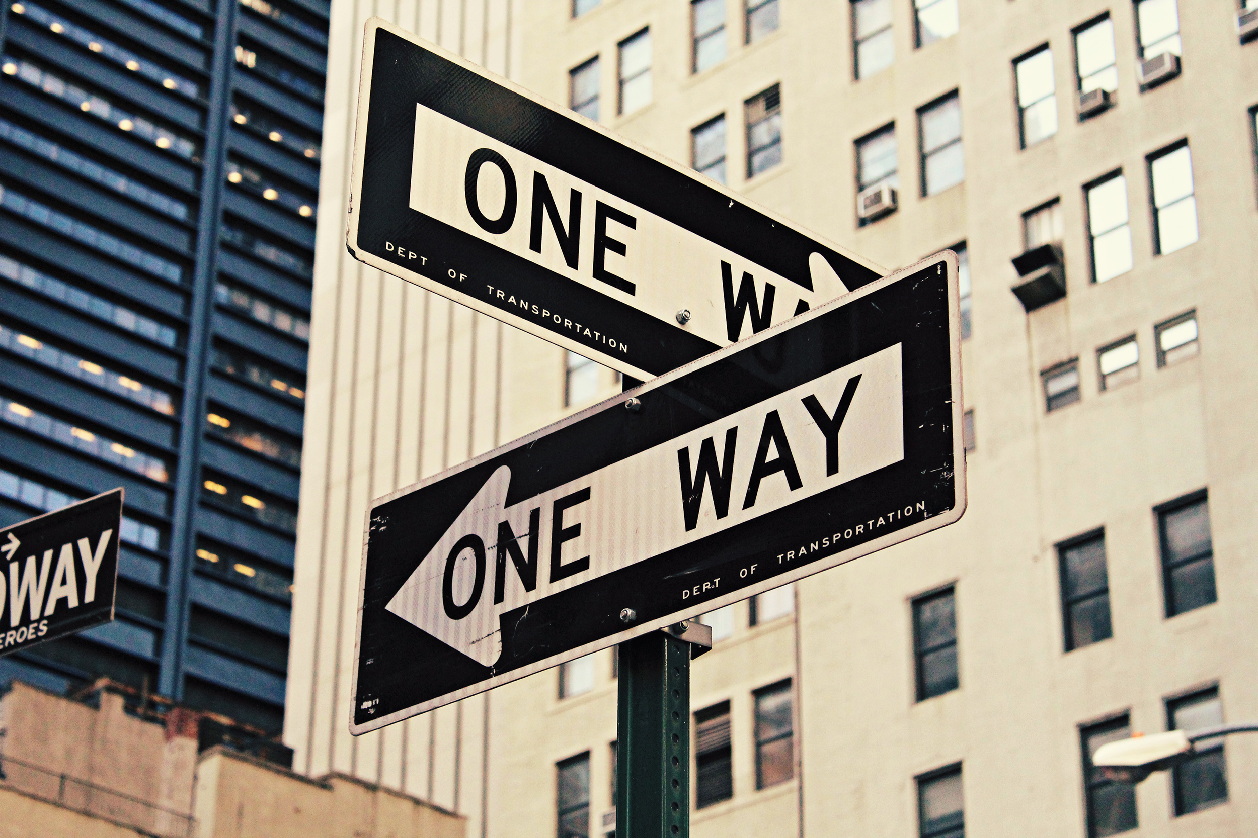 Traffic signs that say One Way in an urban setting