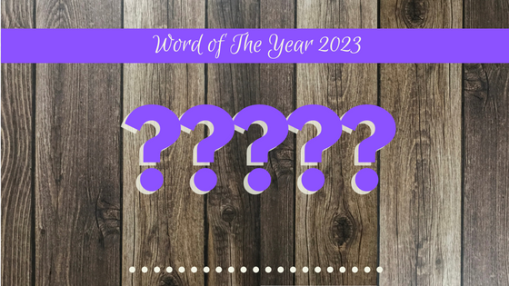 Wood panels in background with the words Word of the Year 2023 and question marks supporting the question of what Denise M. Colby will pick for a focus word in 2023
