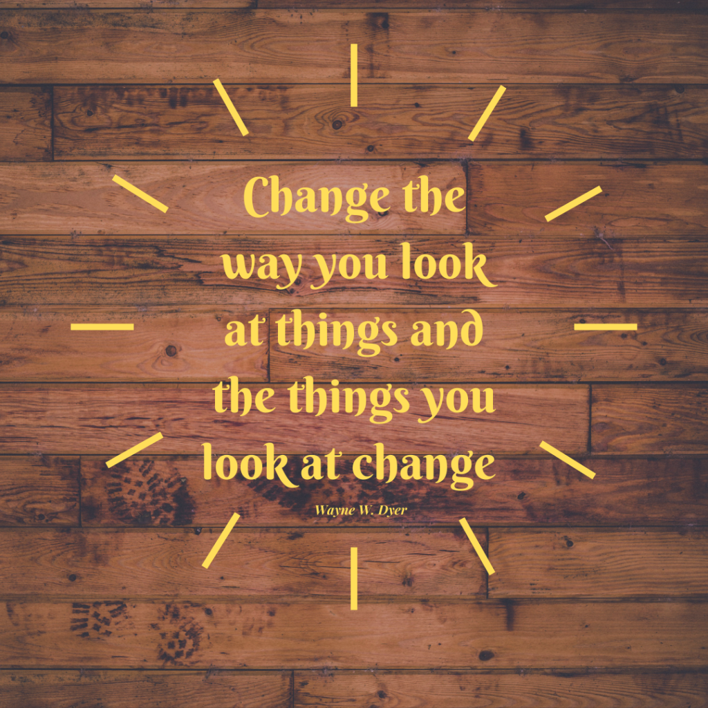 Change the way you look at things and the things you look at change quote in yellow with wood floor background