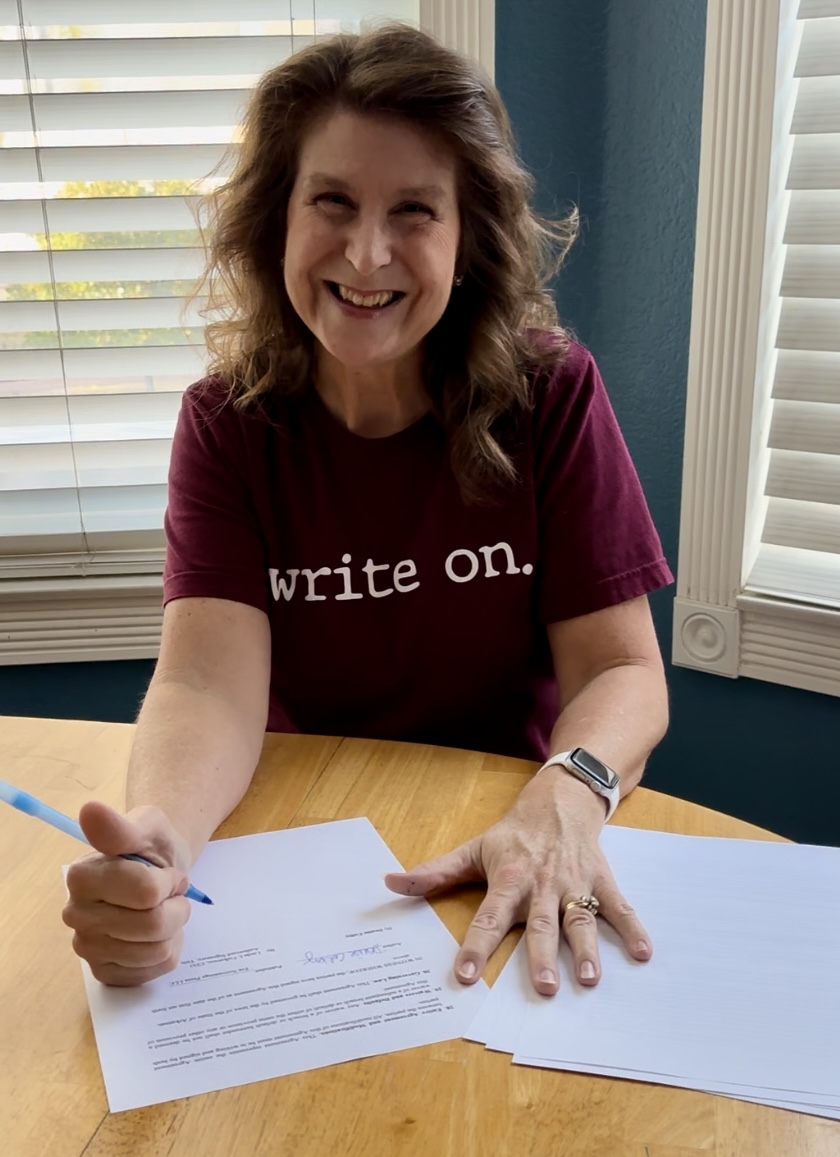 Denise M. Colby signing her first contract with Scrivenings Press for her first historical romance series titled "Best-laid Plans"