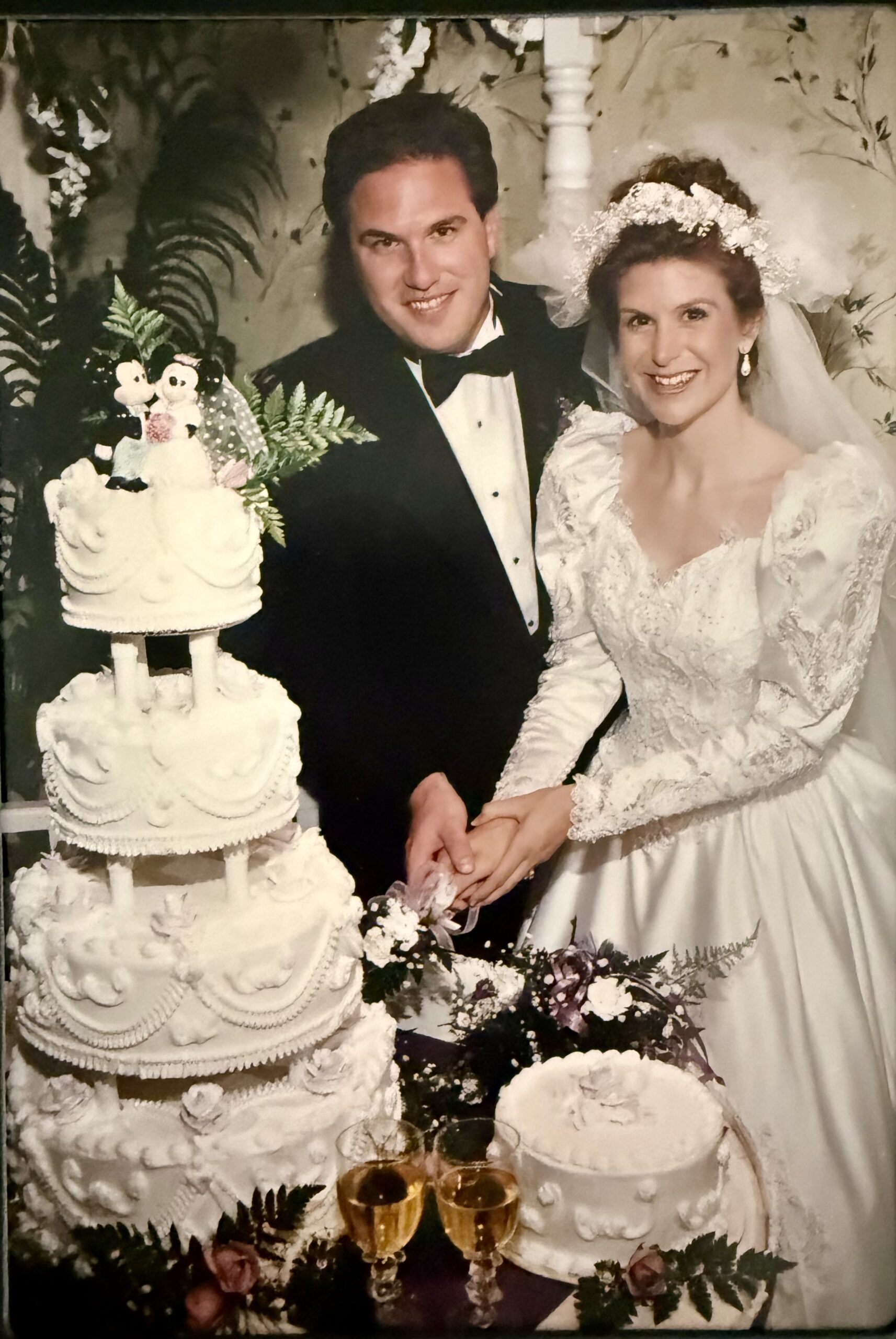 Ken and Denise Colby wedding pic 1995 with Disney cake topper and Disney toasting glasses