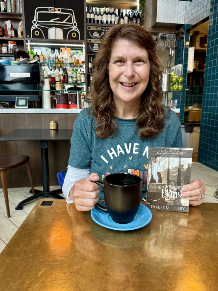 Denise M. Colby holding a book cover on release day A Slight Change of Plans