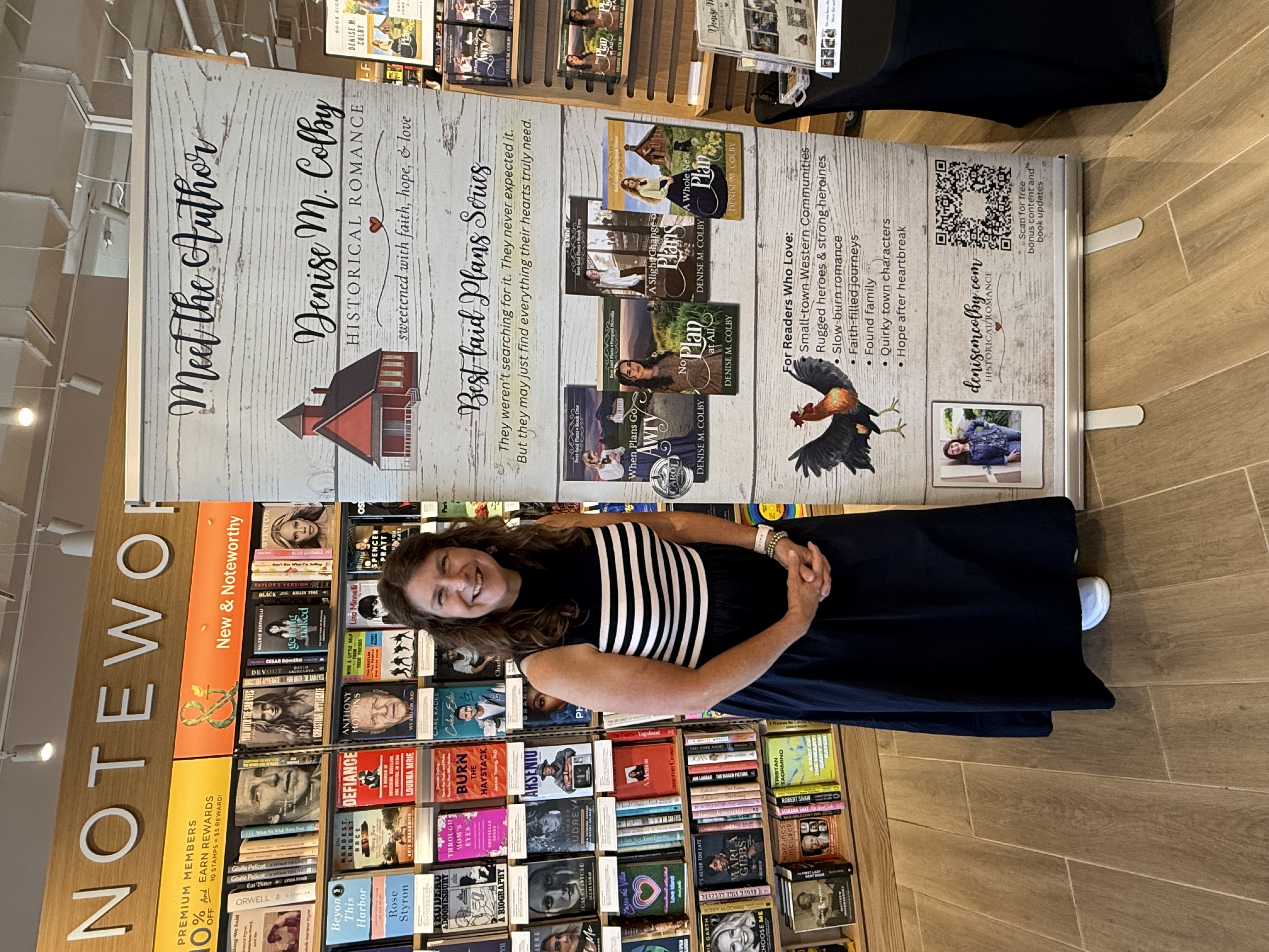 Denise M. Colby standing next to her author banner sign at her Barnes & Noble Book Signing
